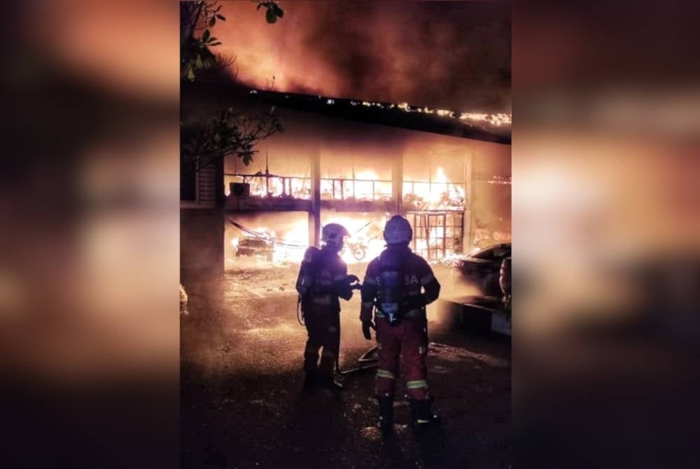 Anggota bomba memadamkan kebakaran di bengkel kenderaan IPK Kedah.