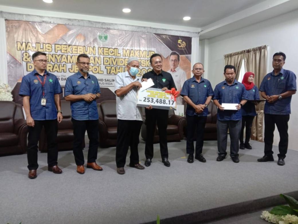 Mohd Salim ( empat dati kiri) ketika menyampaikan dividen TSK kepada penerima.