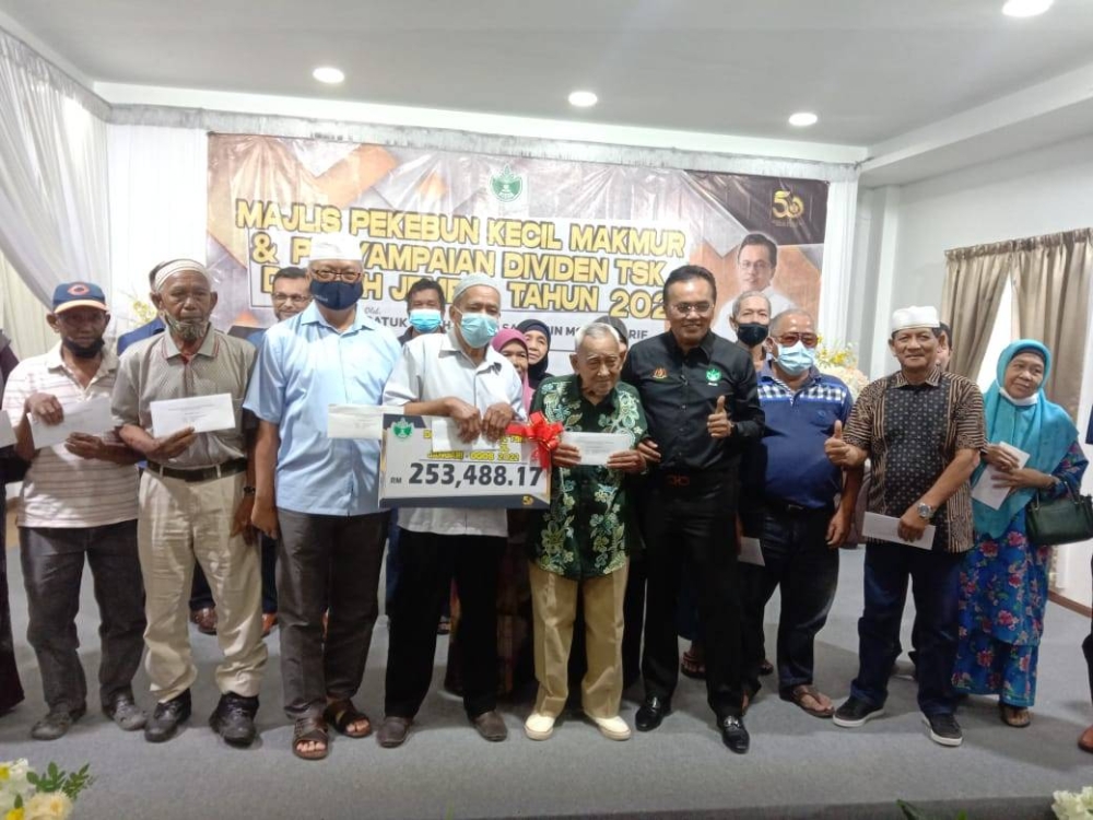 Mohd Salim (enam dari kiri) bersama pemilik kebun yang menerima dividen TSK pada Isnin.