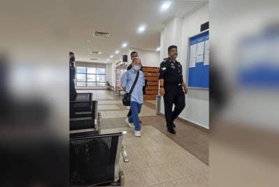 Tertuduh (kiri) mengaku tidak bersalah di Mahkamah Sesyen Georgetown terhadap empat pertuduhan menjadi dalang dalam kegiatan pelacuran pada Ogos lalu.