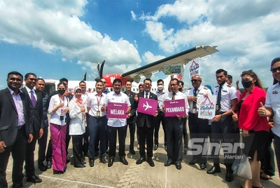 Muhammad Jailani (lapan dari kiri) bergambar di depan pesawat Batik Air yang selamar mendarat di LTAM di Batu Berendam di sini, pada Isnin.
