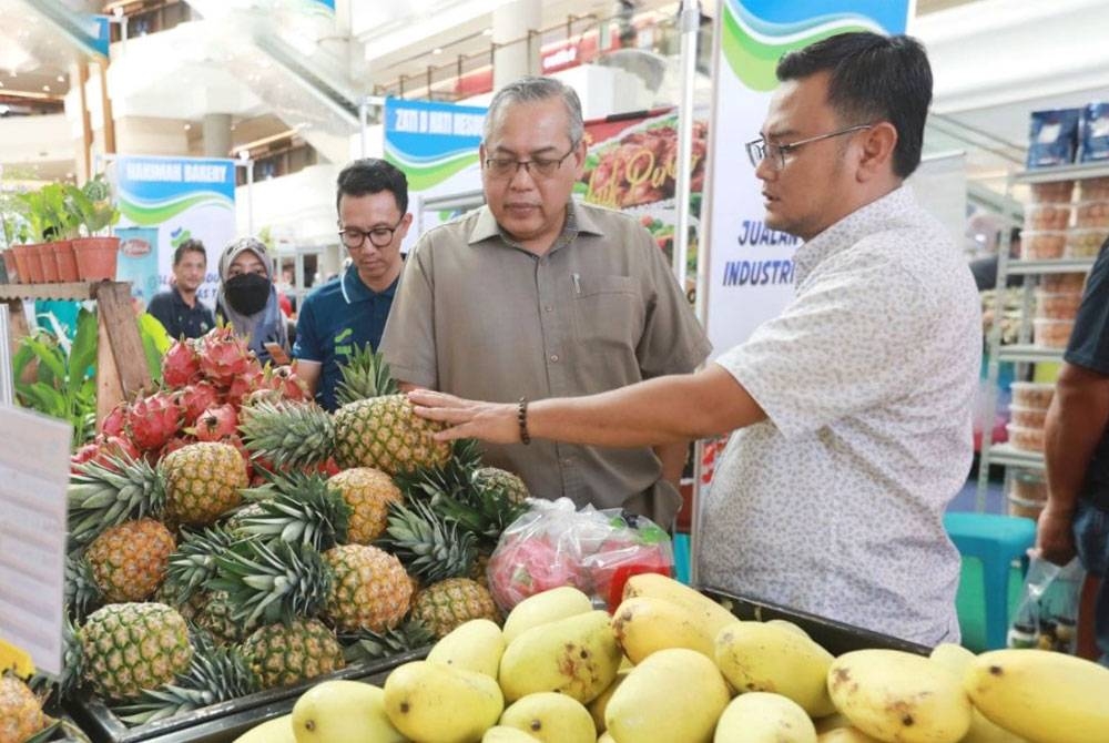 Ketua Pengarah FAMA, Datuk Zainal Abidin Yang Razalli ditemani Saiful (kanan) ketika melawat program Jualan Agro Makanan di sebuah pusat beli-belah di Kuantan.