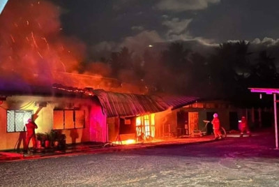Pasukan bomba memadamkan kebakaran membabitkan dewan makan SMK Kota Marudu 1, di Kota Marudu pada malam Isnin.