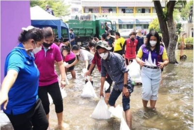 Orang ramai yang berada di kawasan yang rendah kelihatan sibuk membuat penghadang dan menimbun guni pasir di hadapan pintu masuk kedai dan kediaman masing-masing bagi mengurangkan risiko kerugian akibat banjir. - Foto Bangkok Metropolitan Administration