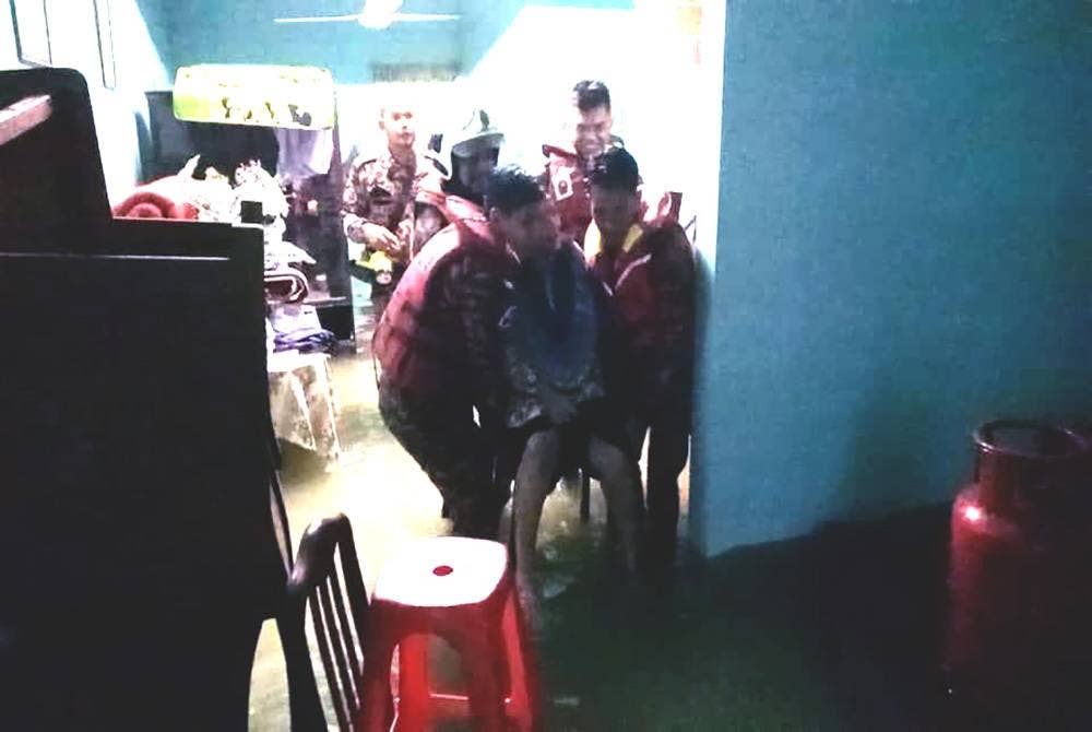 Anggota bomba menyelamatkan mangsa banjir yang terperangkap di Kampung Sri Gading.