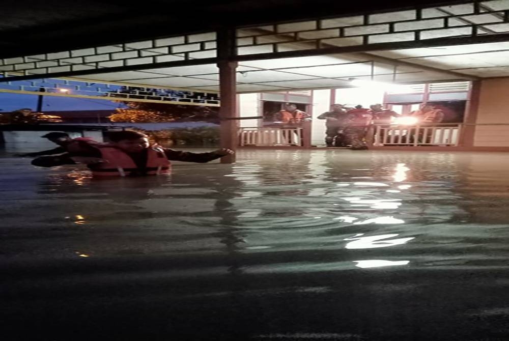 Anggota bomba menyelamatkan mangsa banjir yang terperangkap di Kampung Sri Gading.