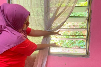 Siti Nor Rafeeqa menunjukkan tingkap rumahnya yang diumpil pencuri dalam kejadian di Kampung Gong Mengkelih, Pasir Puteh.