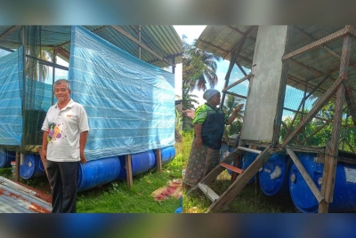 Mohd Aris (gambar kiri) dan Normah berada di hadapan rumah rakit milik mereka sebagai persediaan berdepan musibah banjir.