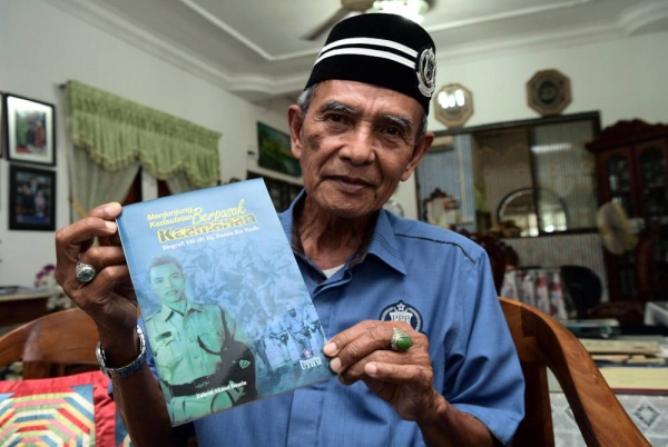 Sarjan Mejar (B) Damin Hadis, 77, menunjukkan buku 'Menjunjung Kedaulatan Berpasak Keamanan' yang menceritakan kisah hidup dan pengalaman yang ditempuhnya ketika berkhidmat dalam PDRM semasa ditemui di rumahnya di Pekan Pekan Nanas, Pontian baru-baru ini. - Foto Bernama
Perjalanan kisah Damin telah dibukukan, hasil penulisan anaknya yang merupakan Pensyarah Kanan Pusat Pengajian Umum dan Kokurikulum, Universiti Tun Hussein Onn Malaysia (UTHM) Dr Zahrul Akmal yang berjudul ‘Menjunjung Kedaulatan Berpasak Keamanan: Biografi SM (B) Hj Damin Bin Hadis’ yang diterbitkan pada 20 Feb 2020.
--fotoBERNAMA (2022) HAK CIPTA TERPELIHARA