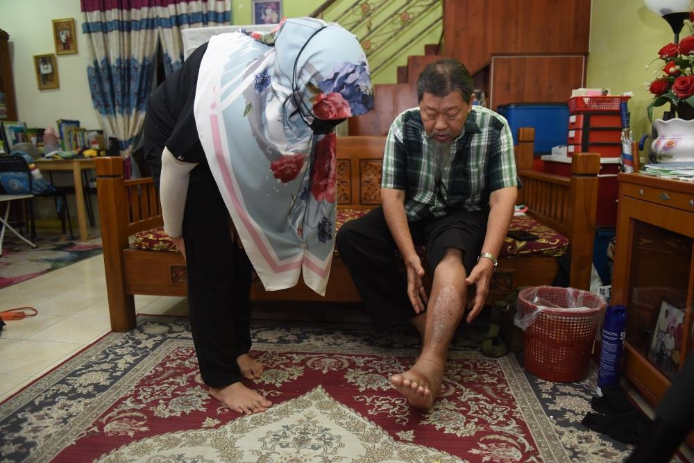 Dr Syakirah memeriksa kaki Abdul Wahab yang bengkak.