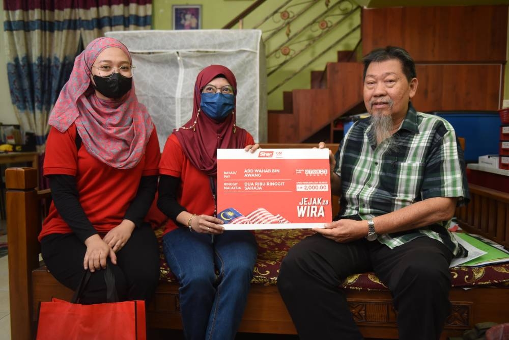 Norsuhaida (tengah) menyerahkan mock-up cek sumbangan sebanyak RM2,000 kepada Abdul Wahab.