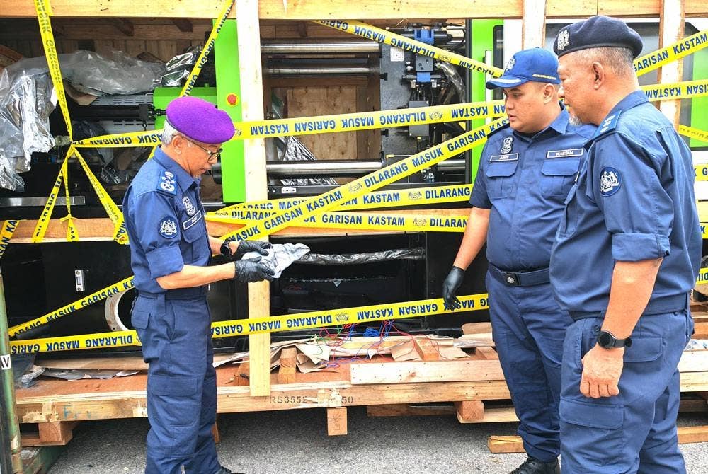 Zazuli (kiri) menunjukkan mesin acuan industri yang digunakan untuk menyembunyikan dadah.