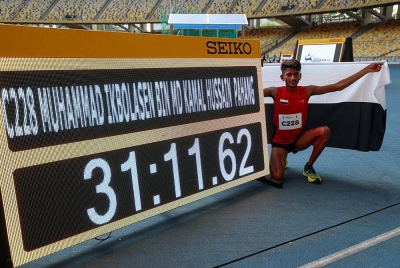 Muhammad Ikbolasen bergambar bersama catatan masa dilakukannya selepas menamatkan larian dalam acara 10,000m lelaki akhir pada Sukan Malaysia (SUKMA) Stadium Nasional Bukit Jalil hari ini. Foto-Bernama