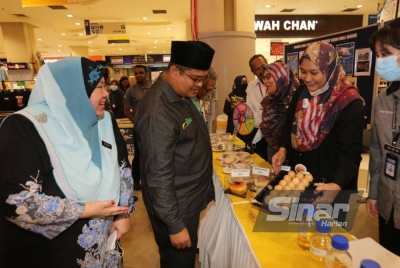 Mohd Akmal bersama Timbalan Pengarah Kesihatan Negeri (Bahagian Keselamatan dan Kualiti Makanan), Afiedah Munir@Muhammad meninjau ruang pameran disediakan.