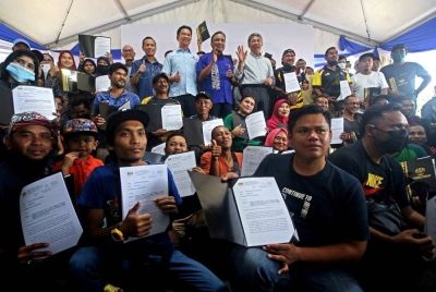 Reezal Merican (tengah) bersama penerima rumah baharu pada program Penyerahan Surat Tawaran dan Pengisian PPR Rantau di Taman Seri Intan pada Khamis. - Foto Bernama