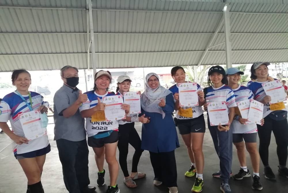 Rodziah (lima dari kanan) bergambar bersama peserta Ampang Heritage Fun Run di Kampung Baru Ampang pada Jumaat.