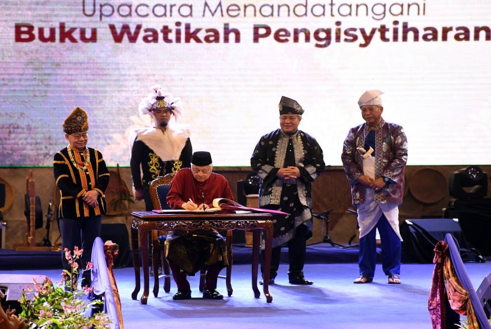 Perdana Menteri Datuk Seri Ismail Sabri Yaakob menandatangani Buku Watikah Pengisytiharan pada sambutan Hari Malaysia 2022 di Dataran Memorial Pengisytiharan Kemerdekaan A'Famosa Banda Hilir malam Jumaat. Turut kelihatan Menteri Komunikasi dan Multimedia Tan Sri Annuar Musa (kanan), Timbalan Ketua Menteri Sabah II Datuk Seri Jeffrey Kitingan (kiri) dan Timbalan Premier Sarawak Datuk Amar Awang Tengah Ali Hasan (dua, kanan). - Foto Bernama