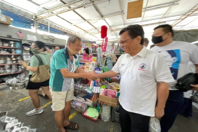 Shafie bersalaman dengan salah seorang peniaga di Pasar Awam Lip Sin ketika program ramah mesra pada Jumaat.
