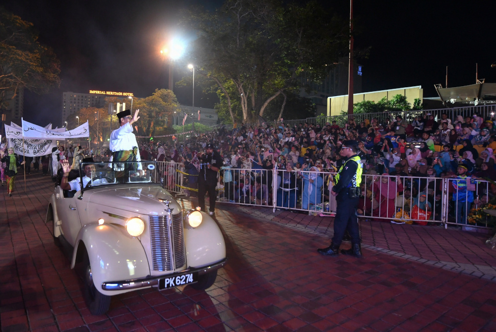 Pelakon semula watak Tunku Abdul Rahman, Che’ Kem menaiki kereta antik diarak bersama rombongan dalam segmen persembahan ‘Jejak Merdeka’ pada sambutan Hari Malaysia 2022 di Dataran Memorial Pengisytiharan Kemerdekaan A' Famosa Banda Hilir malam Jumaat. - Foto Bernama