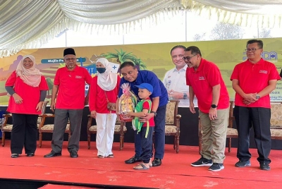 Reezal Merican (tengah) menyampaikan hadiah saguhati kepada peserta ketika melancarkan Program Visit My Kampung Homestay Kota Aur@Perda di Penaga pada Sabtu.