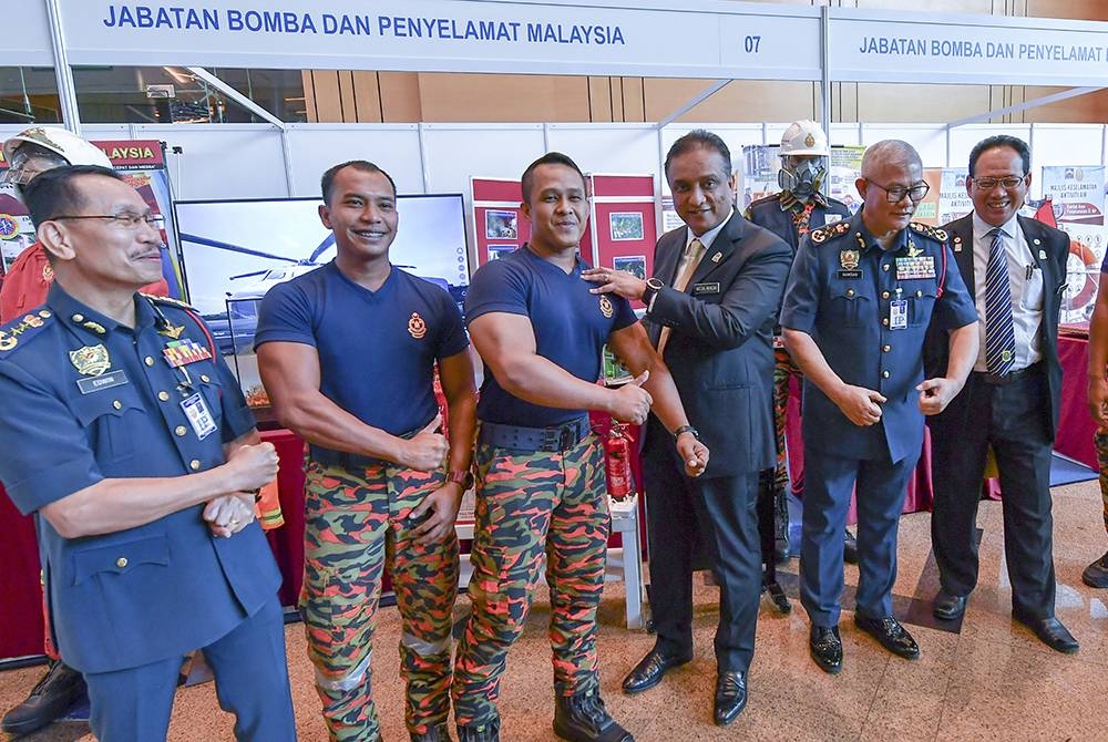 Menteri Perumahan dan Kerajaan Tempatan, Datuk Seri Reezal Merican Naina Merican (tiga, kanan) bersama anggota bomba selepas merasmikan Seminar Undang-Undang Kecil Bangunan Seragam 1984 (Pindaan 2021) di Pusat Konvensyen Antarabangsa Putrajaya (PICC) - Foto Bernama.