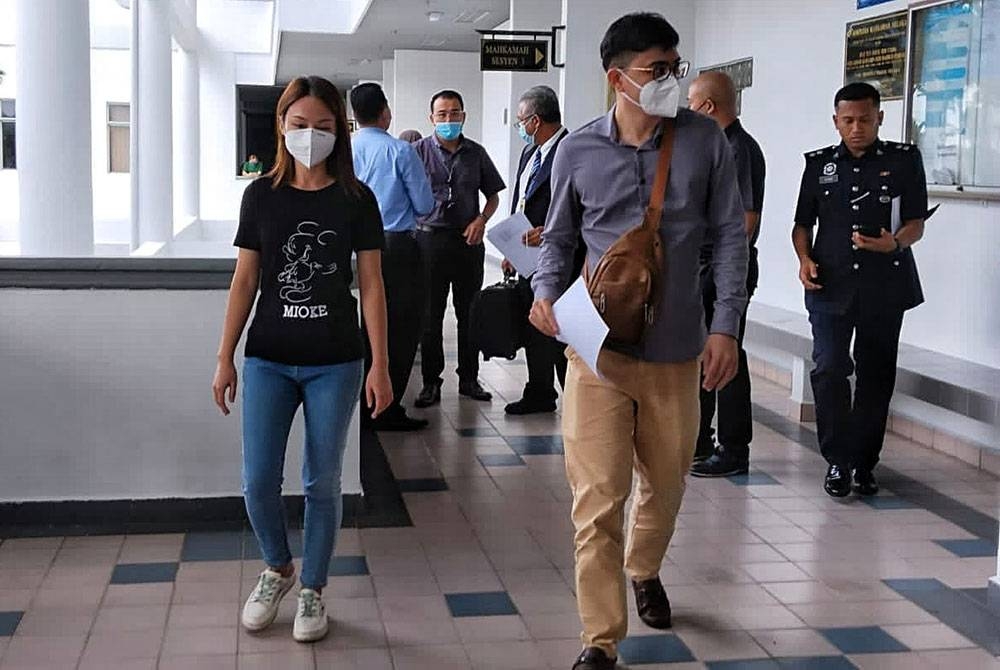 Jun Yin (kiri) dan suaminya ketika tiba di Mahkamah Sesyen di sini, pada Isnin.