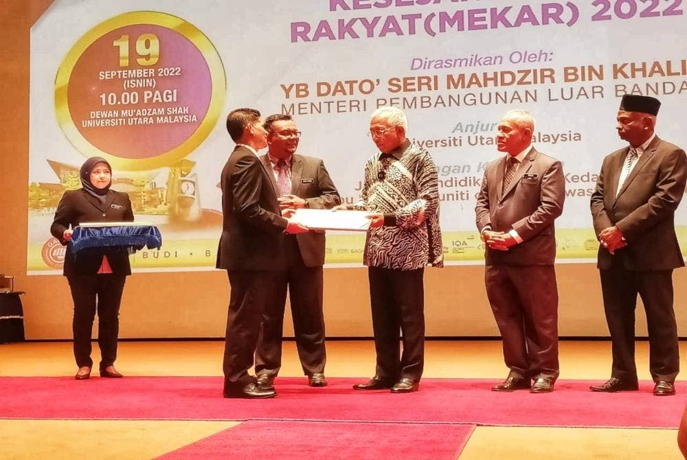 Menteri Pembangunan Luar Bandar, Datuk Seri Mahdzir Khalid ( tiga, kanan) menyerahkan watikah pelantikan kepada wakil sekolah yang terpilih untuk mengikuti projek UUM- PIBKS Membina Kesejahteraan Rakyat (Mekar), pada Isnin.