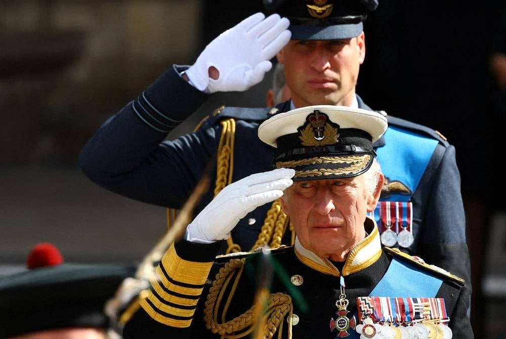 Raja Charles III dan Putera William memberi penghormatan terakhir semasa majlis persemadian negara di London. - AFP
