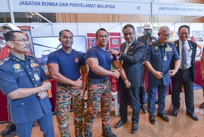 Menteri Perumahan dan Kerajaan Tempatan, Datuk Seri Reezal Merican Naina Merican (tiga, kanan) bersama anggota bomba selepas merasmikan Seminar Undang-Undang Kecil Bangunan Seragam 1984 (Pindaan 2021) di Pusat Konvensyen Antarabangsa Putrajaya (PICC) - Foto Bernama.