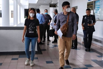 Jun Yin (kiri) dan suaminya ketika tiba di Mahkamah Sesyen di sini, pada Isnin.