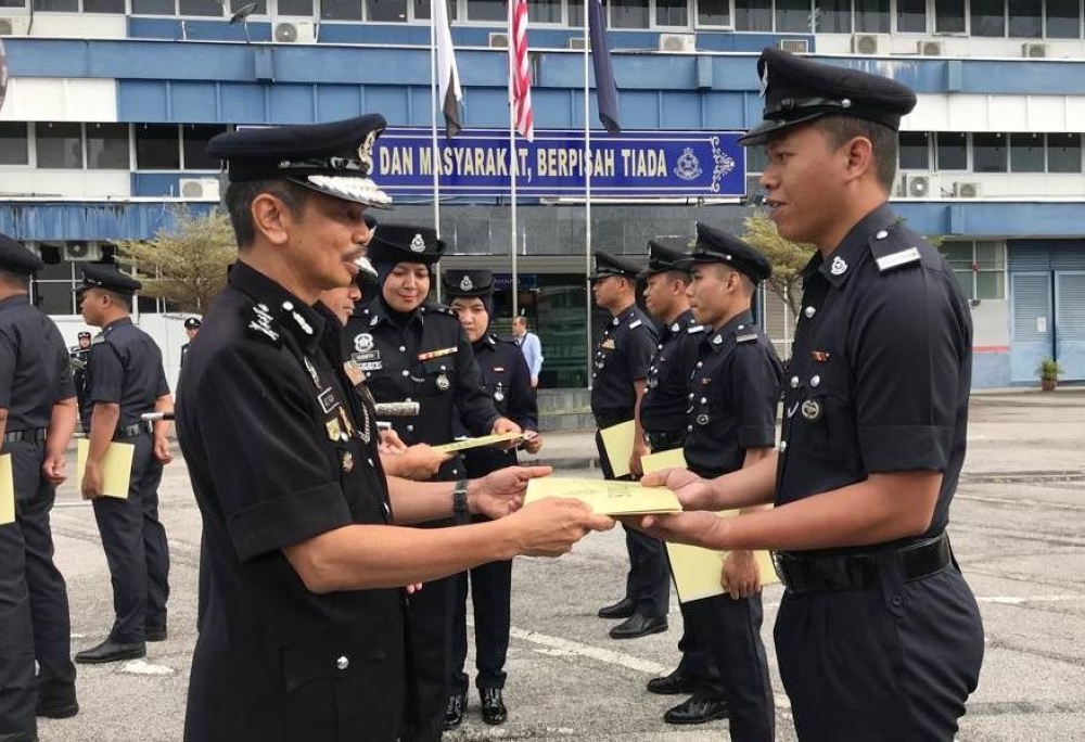 Abdul Razak (kiri) penyampaian sijil penghargaan kepada anggota polis pada perhimpunan bulanan bagi bulan September 2022 anjuran JSJK Pahang di pekarangan IPK Pahang, Kuantan pada Selasa.