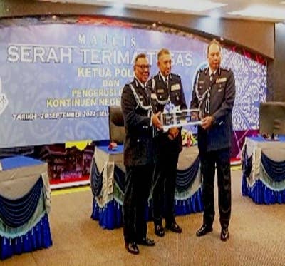 Ruslan (kiri) menyerahkan tongkat kuasa kepada Ahmad Dzaffir disaksikan oleh Azri (tengah).