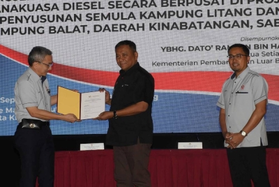 Ketua Setiausaha Kementerian Pembangunan Luar Bandar (KPLB), Datuk Ramlan Harun (tengah) menerima dokumen daripada Pengarah Projek LJK10 merangkap Pengurus Besar (Projek Utama) Sabah Electricity Sdn Bhd (SESB) Abdul Razak Salleh (kiri) sempena majlis penyerahan Lampu Jalan Kampung (LJK) dan Janakuasa Diesel Kampung Litang dan Kampung Balat Kinabatangan, pada Selasa. - Foto Bernama
