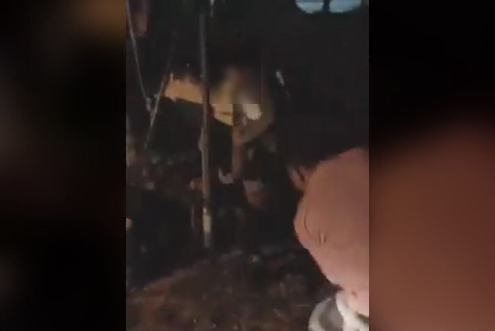 Video tular memaparkan seorang lelaki memukul mangsa dengan menggunakan kayu dalam kejadian di Kampung Pantai Kundur.