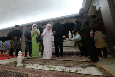 Ahli keluarga terdekat menabur bunga mawar di atas pusara Allahyarham Datuk Seri Mohd Adib Mohamad Adam selepas selamat disemadikan di Makam Pahlawan Masjid Al-Azim Bukit Palah hari ini.