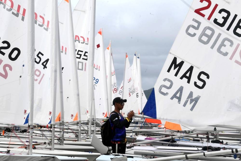  Peserta acara ILCA 6 (lelaki) Asmadi Azman dari Terengganu memasang 'outhaul line' di botnya pada hari terakhir acara perahu layar pada Sukan Malaysia (Sukma) 2022 di Pusat Latihan Perahu Layar Kebangsaan Langkawi.