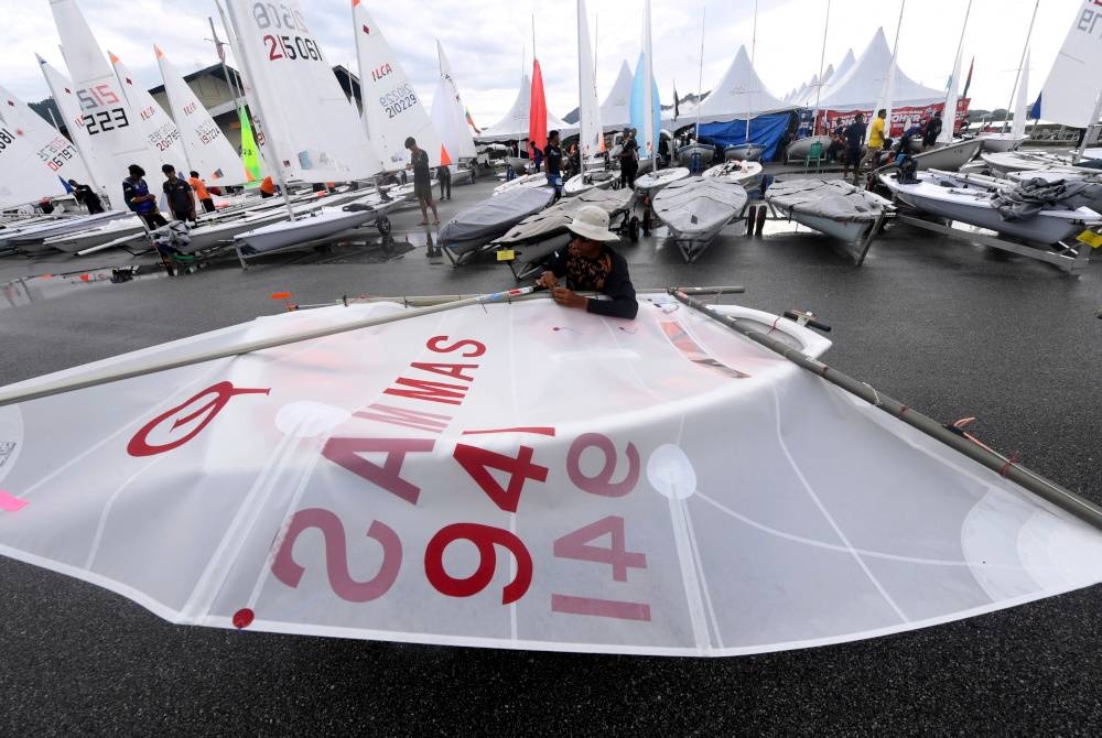 Peserta acara Optimis (lelaki) dari Kedah, Mohd Zikri Zakaria memasang layar di botnya pada hari terakhir acara Perahu Layar pada Sukan Malaysia (Sukma) 2022 di Pusat Latihan Perahu Layar Kebangsaan Langkawi.