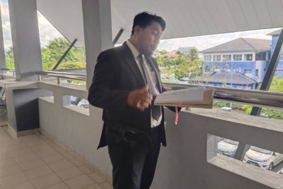 Akif Rusli meneliti dokumen yang diterima daripada pihak pendakwaan pada prosiding sebutan semula kes bunuh Khalid Redza dan anak perempuannya.