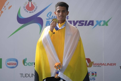 Muhammad Abdul Qaiyum menunjukkan pingat Emas yang dimenanginya pada acara tinju 46-48 KG pada Sukan Malaysia 2022 (Sukma) pada Jumaat. - Foto Bernama