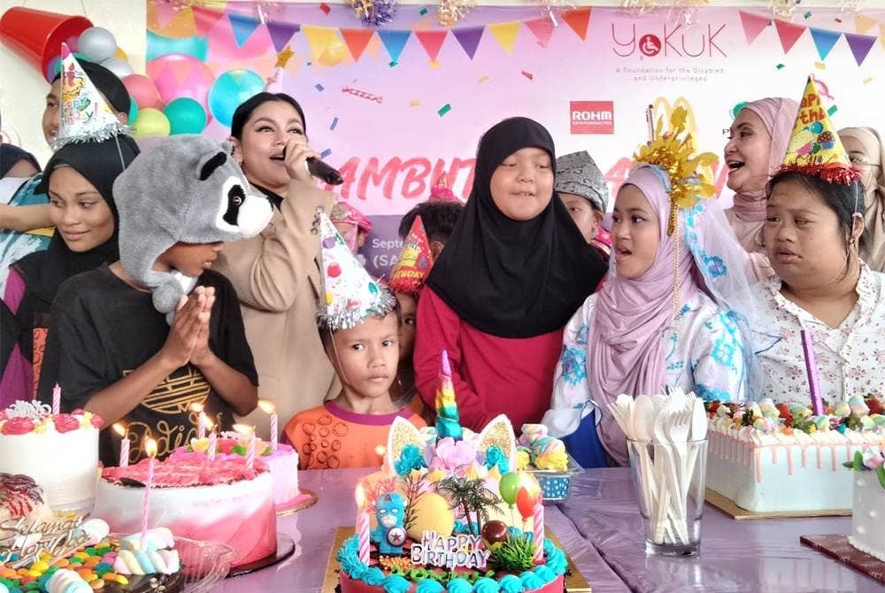 Suliana (belakang, kanan) dan Kaka (tiga dari kiri) meraikan kanak-kanak sempena Program Amal YOKUK Karnival 2022 pada Sabtu.