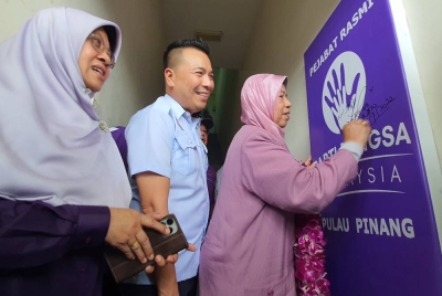 Zuraida (kanan) menurunkan tandatangan sebagai simbolik perasmian pejabat PBM di Taman Seri Delima, Juru pada Sabtu.