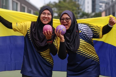 Ain Nurnajwa (kiri) dan Nur Nadhirah (kanan) meraikan kejayaan selepas beraksi dalam acara boling padang kategori Pairs Akhir menentang pasukan Kedah pada Sukma di Kompleks Sukan Bukit Kiara, pada Sabtu. - Foto Bernama
