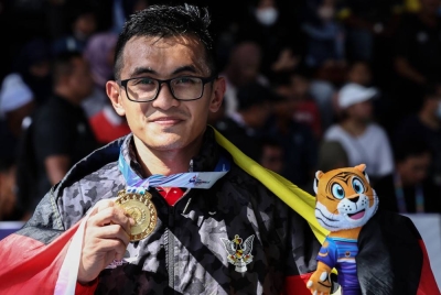Jackson menunjukkan pingat emas dimenanginya dalam acara tinju 54-57kg lelaki Sukma MSN 2022 di Kompleks Futsal Presint 18 pada Sabtu. - Foto Bernama