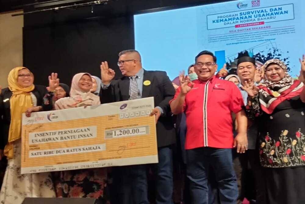 Ahmad Raslan (dua dari kanan) bersama penerima geran sempena Majlis Penyerahan Geran Insentif Perniagaan myUBI kepada golongan terkesan pandemik di sini pada Sabtu.