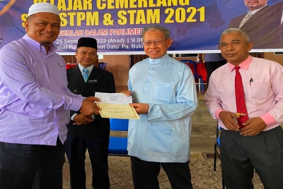 Mustapa (dua dari kanan) menyampaikan sumbangan pada Majlis Penyampaian Sumbangan Pelajar Cemerlang SPM, STPM & STAM 2021 di Jeli pada Ahad.