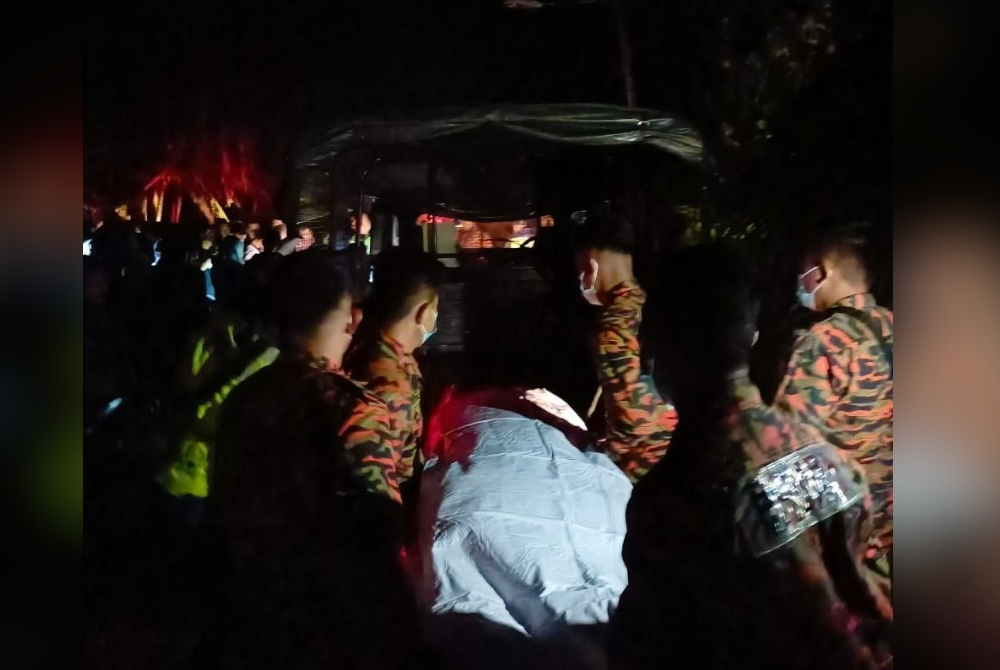 Anggota bomba mengangkat mayat seorang pemuda yang ditemukan maut dalam longkang di Jalan Sanglang Laut, Ayer Baloi dekat Pontian pada malam Ahad.