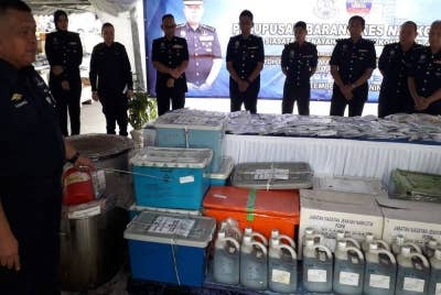 Kamarul Zaman menunjukkan pelbagai jenis dadah yang akan dilupuskan, selepas sidang akhbar di IPK Johor, Johor Bahru, pada Isnin.