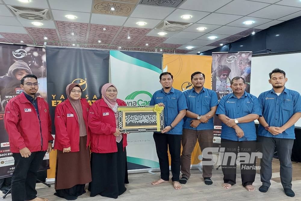 Pengerusi Syria Care, Siti Sakinah Meor Omar Baki menyerahkan cenderahati kepada Pengurus Operasi Yayasan EZ Prihatin Muhammad Zulfadhli Mohamad Zain