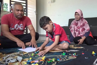 Mohd Nor Syam (kiri) dan Rozela (kanan) melihat anaknya bermain.