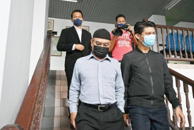 Mohamad Yusof (kiri) ketika keluar dari Mahkamah Sesyen pada Rabu.